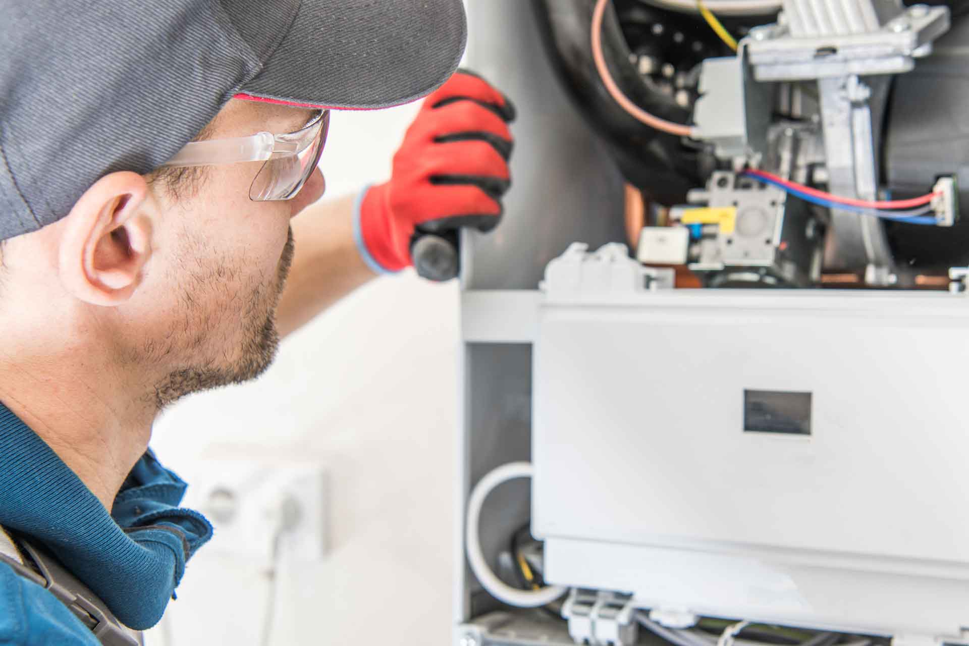 HVAC technician carefully servicing a heating system
