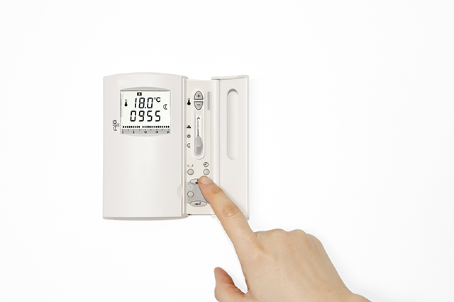 Hand adjusting a thermostat